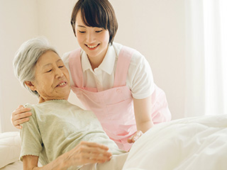 ベッドで見を起こす補助をする様子